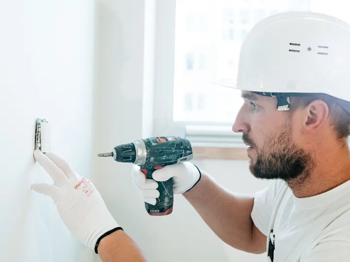 Handyman driving an anchor into a wall