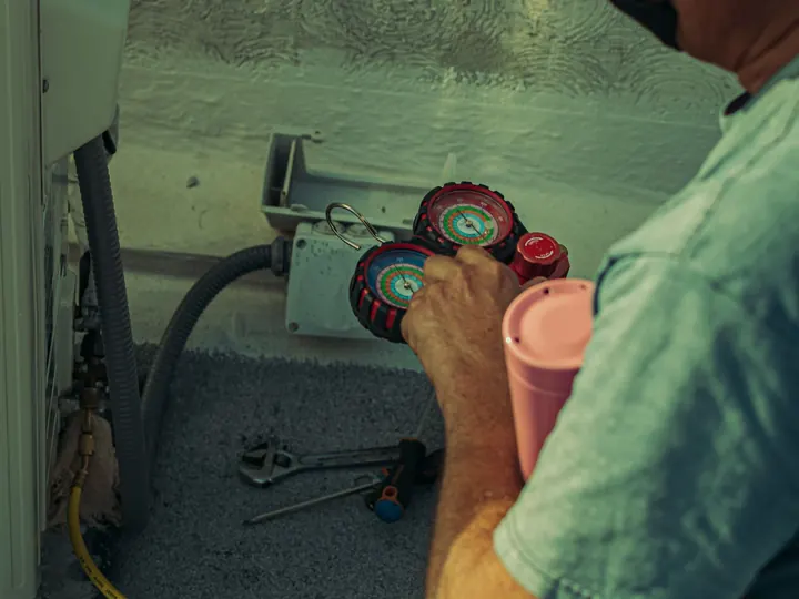 HVAC tech reading manifold gauges