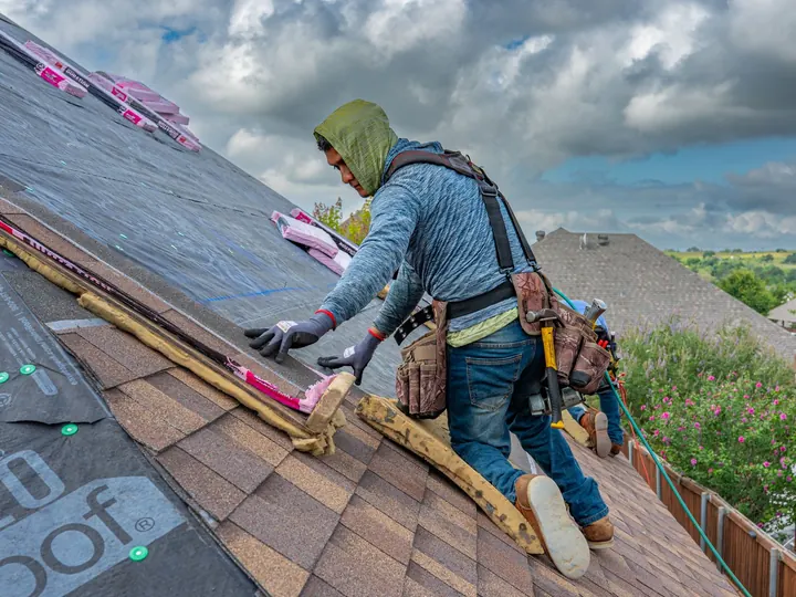 Roofer laying shingles